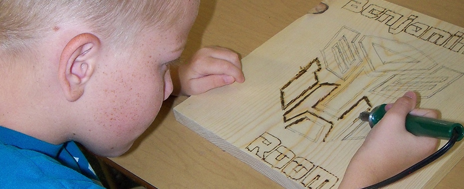 A Child Working on Wooden Art Project